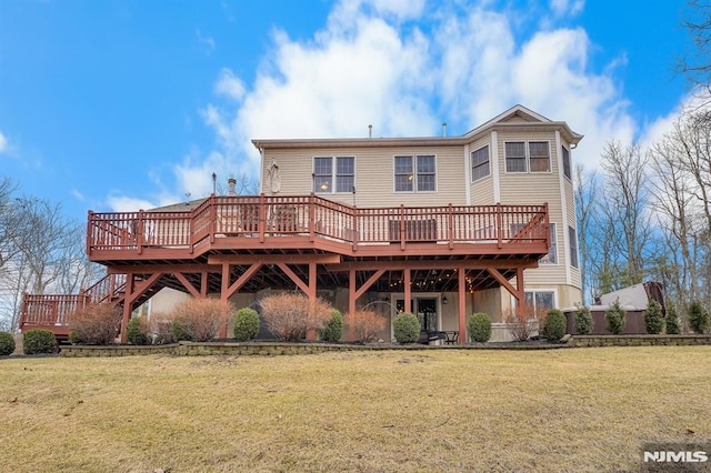 rear view of house featuring a lawn and a wooden deck