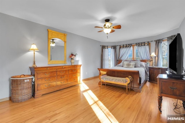 bedroom featuring light wood-style floors, baseboards, and ceiling fan