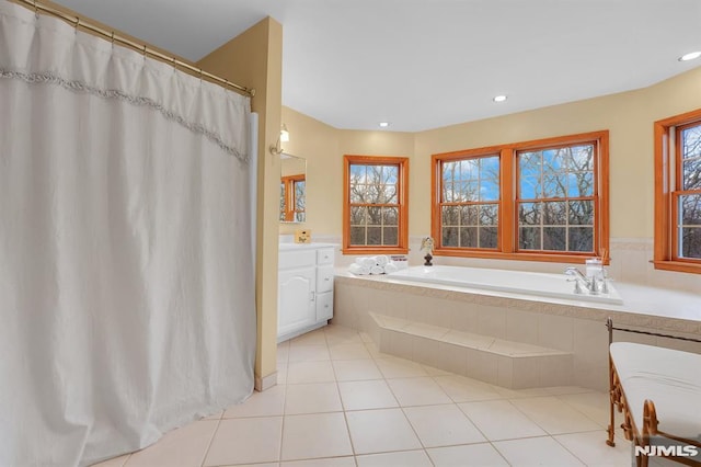 bathroom featuring tile patterned flooring, plenty of natural light, a bath, and vanity