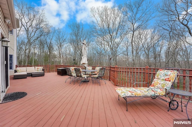 wooden terrace featuring outdoor dining space and an outdoor living space