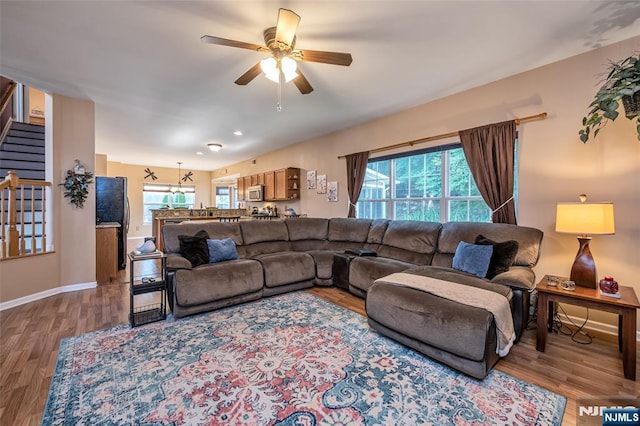 living room featuring ceiling fan and light wood-type flooring