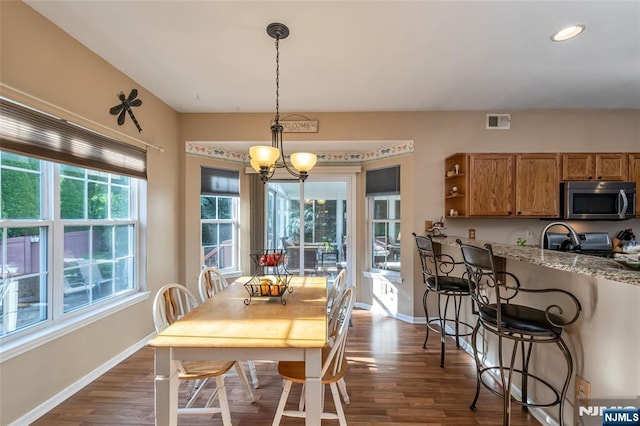 dining area with dark hardwood / wood-style flooring and a notable chandelier