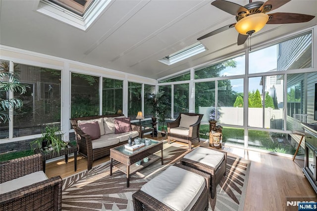 sunroom with ceiling fan and vaulted ceiling with skylight