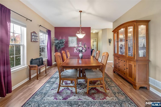 dining area with lofted ceiling and light wood-type flooring