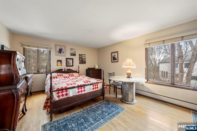 bedroom featuring a baseboard radiator and light hardwood / wood-style flooring