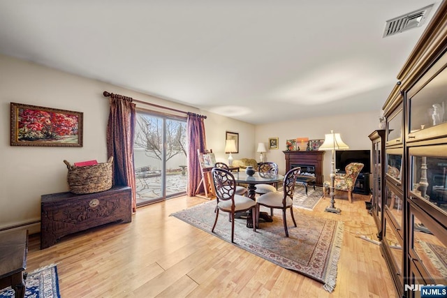 dining space with a baseboard heating unit and light wood-type flooring