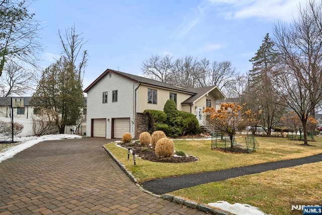 view of front of home featuring a garage and a front lawn