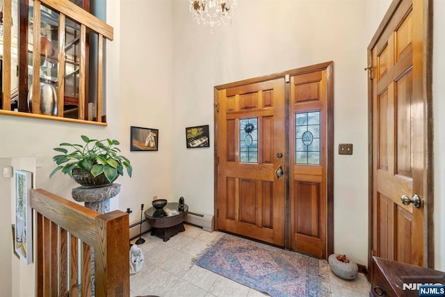 entryway featuring a baseboard heating unit, light tile patterned flooring, a chandelier, and a high ceiling