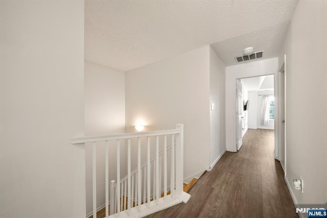 hall featuring dark hardwood / wood-style floors and a textured ceiling