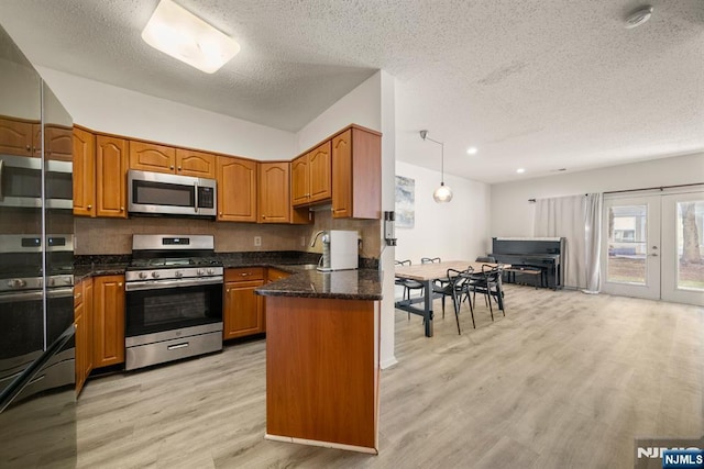 kitchen featuring pendant lighting, sink, appliances with stainless steel finishes, light hardwood / wood-style floors, and french doors