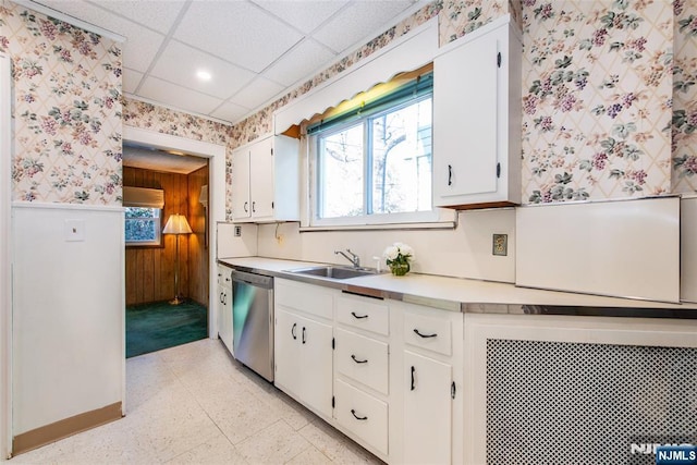 kitchen featuring a paneled ceiling, white cabinetry, dishwasher, sink, and a healthy amount of sunlight