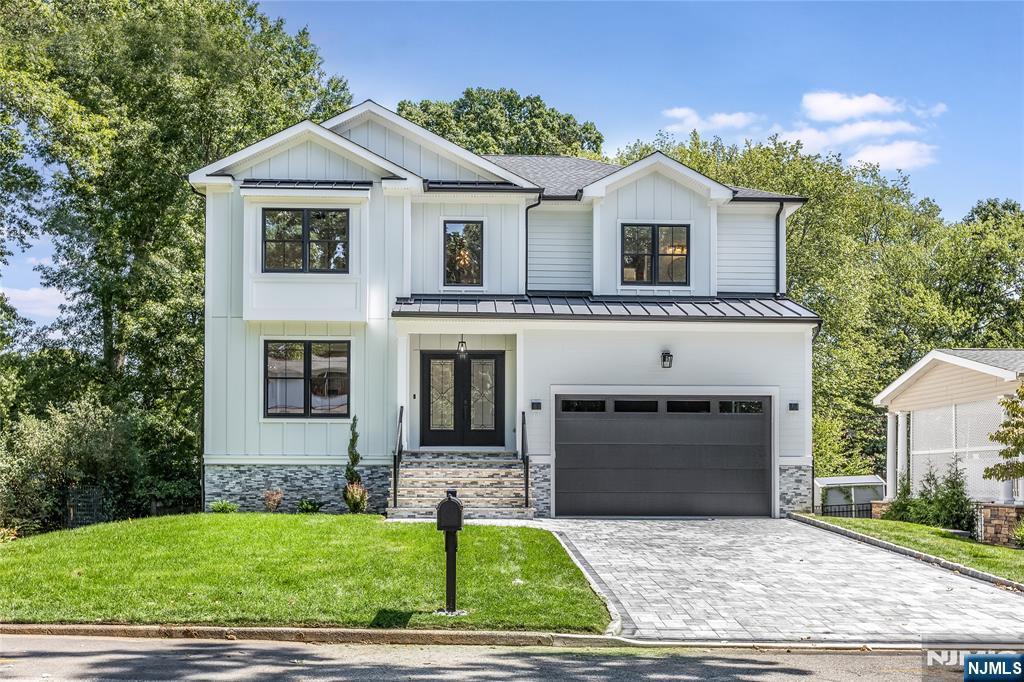 modern farmhouse featuring a garage, a front lawn, and french doors