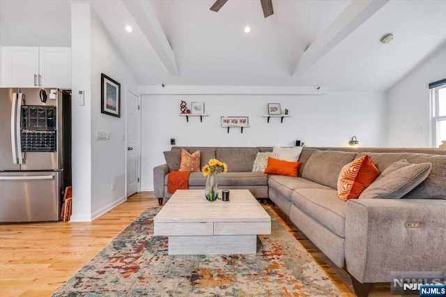 living room featuring ceiling fan, lofted ceiling, and light hardwood / wood-style floors