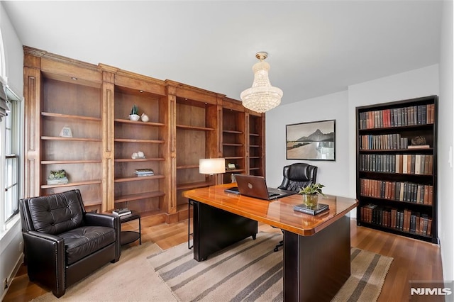 office area featuring an inviting chandelier and hardwood / wood-style flooring