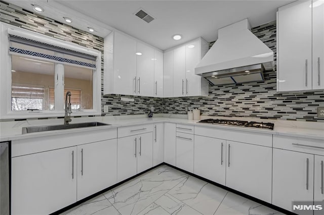 kitchen featuring white cabinetry, stainless steel appliances, sink, and custom range hood