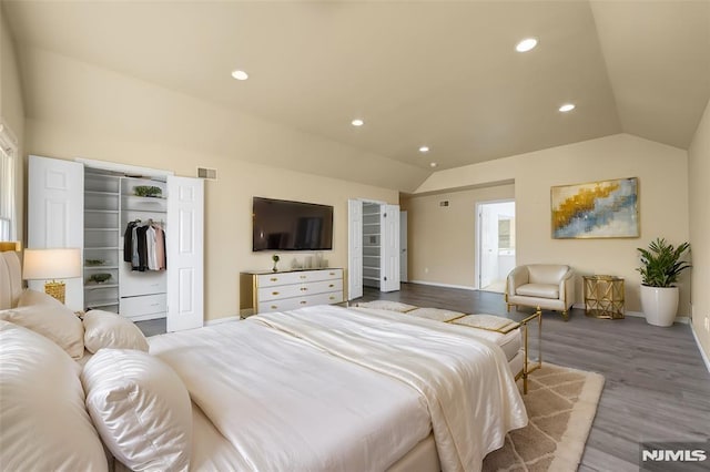 bedroom with light hardwood / wood-style floors, vaulted ceiling, and a closet