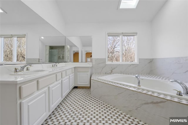 bathroom with vanity, a skylight, and independent shower and bath