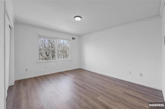 unfurnished room with crown molding and wood-type flooring