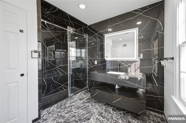 bathroom with sink, tile walls, and a tile shower