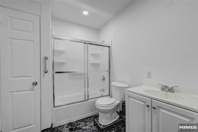 full bathroom with toilet, vanity, and bath / shower combo with glass door