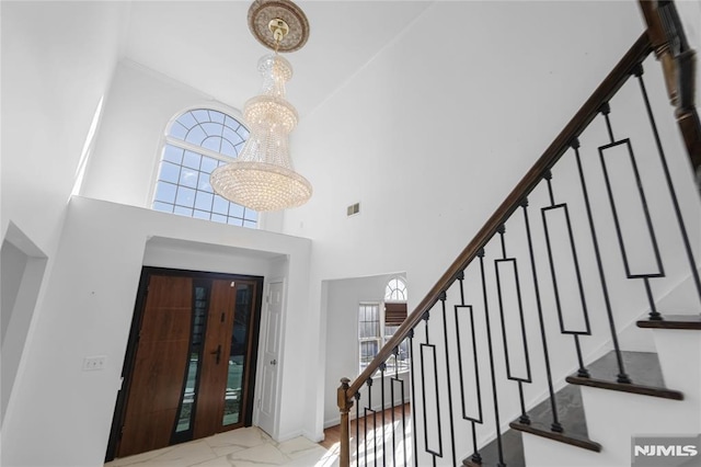 foyer with a towering ceiling and a chandelier