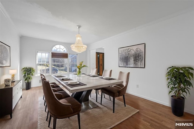 dining space featuring wood-type flooring and ornamental molding