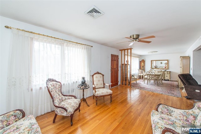 living room featuring ceiling fan, a healthy amount of sunlight, and light hardwood / wood-style floors