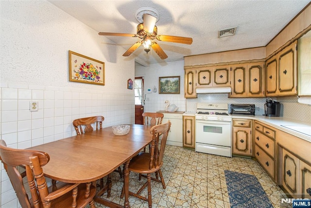 kitchen featuring ceiling fan, gas range gas stove, and a textured ceiling