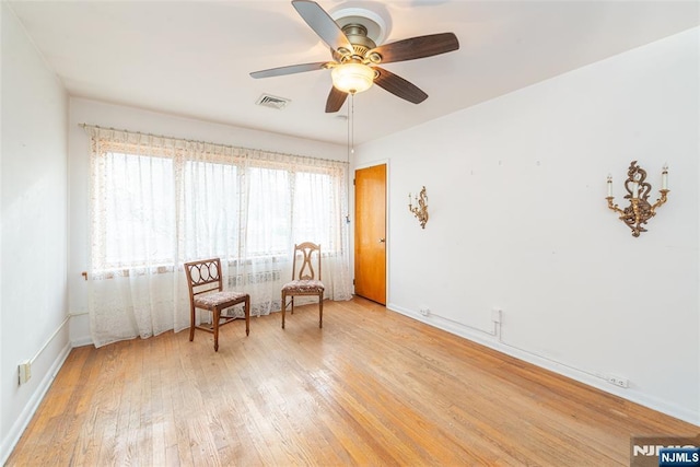 sitting room with ceiling fan and light hardwood / wood-style floors