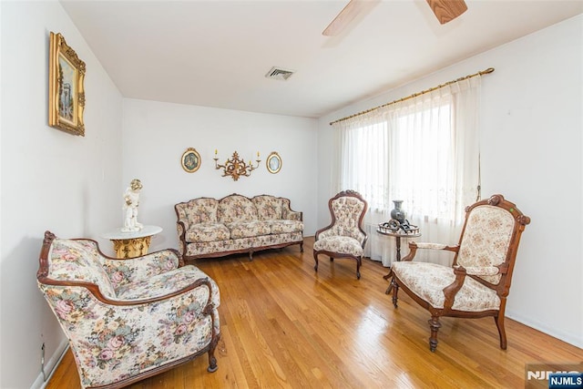 sitting room with ceiling fan and hardwood / wood-style floors