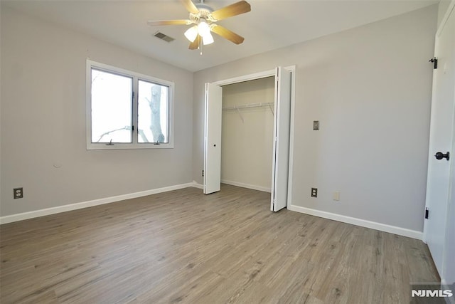 unfurnished bedroom with ceiling fan, a closet, and light wood-type flooring