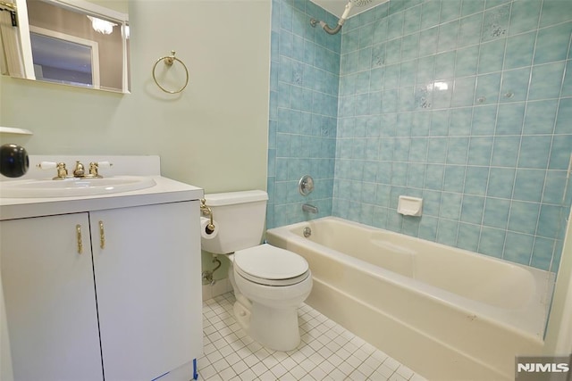 full bathroom featuring tiled shower / bath, tile patterned floors, toilet, and vanity