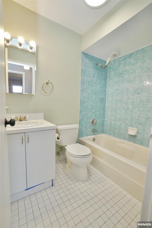 full bathroom featuring vanity, tile patterned floors, toilet, and tiled shower / bath