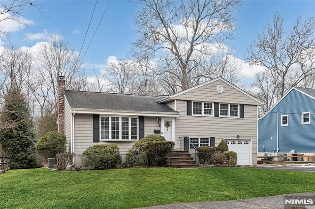 split level home featuring a garage and a front lawn