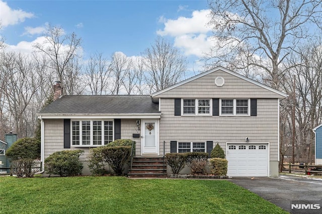 split level home with a garage and a front yard