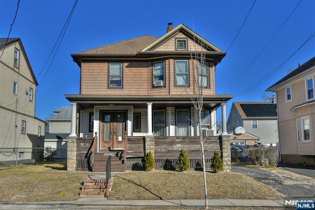 view of front facade with a chimney, fence, cooling unit, french doors, and a porch