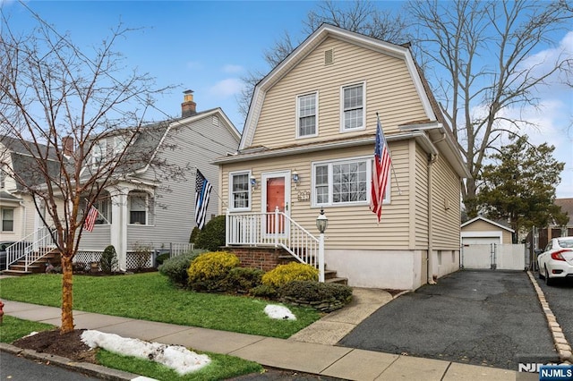 view of front facade with a garage, an outbuilding, and a front yard