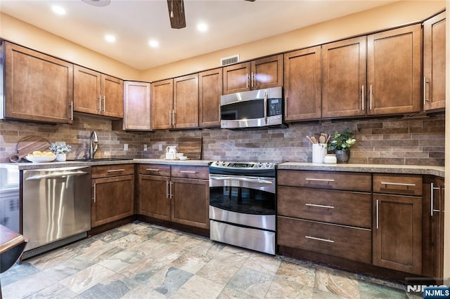 kitchen featuring stainless steel appliances, sink, backsplash, and ceiling fan