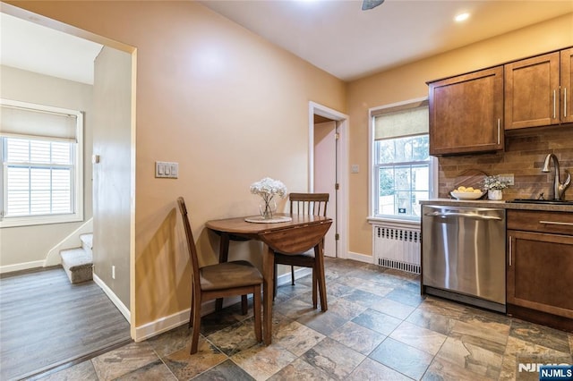 kitchen with dishwasher, radiator, sink, and backsplash