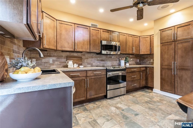 kitchen with appliances with stainless steel finishes, sink, ceiling fan, and decorative backsplash