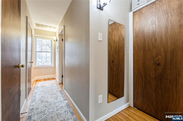 corridor with light hardwood / wood-style flooring