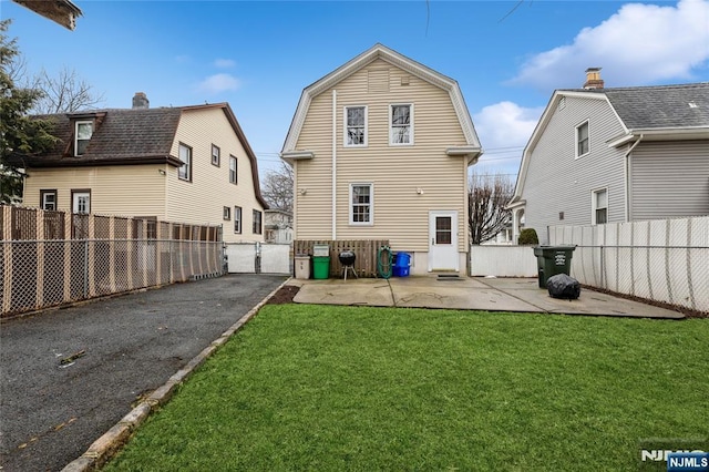 back of property with a yard and a patio area