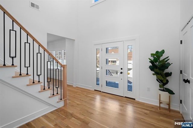 foyer entrance with a high ceiling and light wood-type flooring