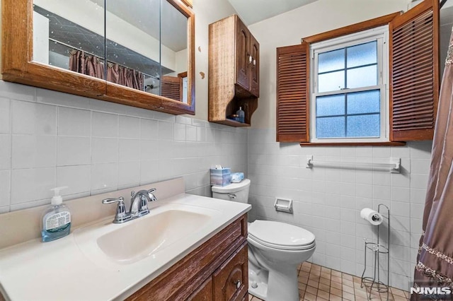 bathroom with vanity, tile patterned floors, toilet, and walk in shower