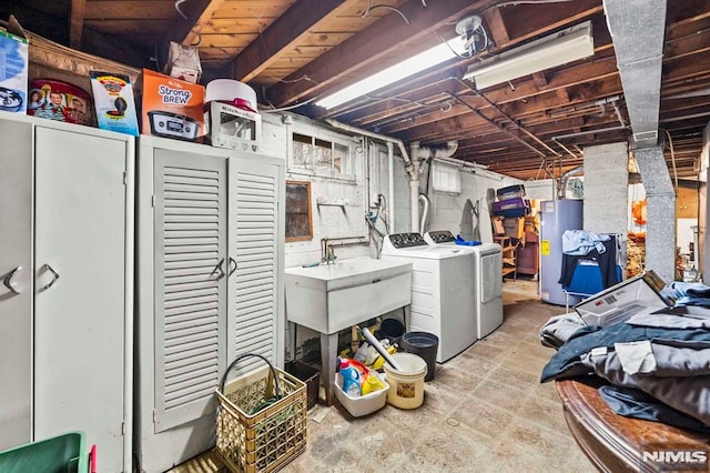 basement with sink, gas water heater, and washing machine and dryer