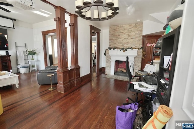 interior space featuring dark wood-type flooring, a fireplace, and an inviting chandelier