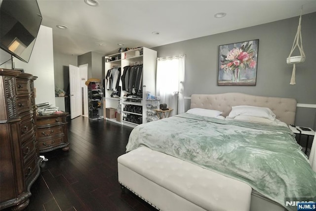 bedroom with dark hardwood / wood-style floors and a closet