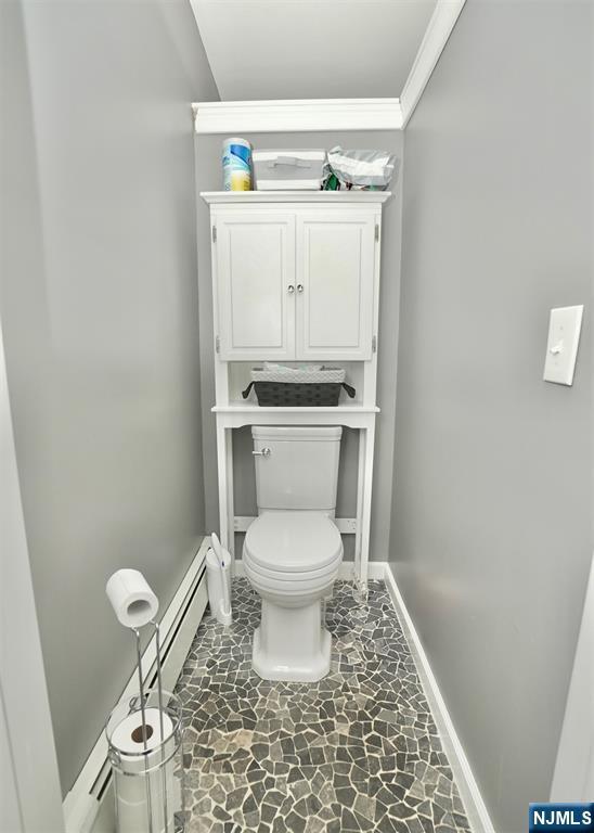 bathroom with ornamental molding and toilet