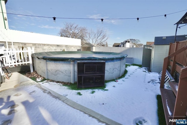 yard covered in snow featuring a covered pool