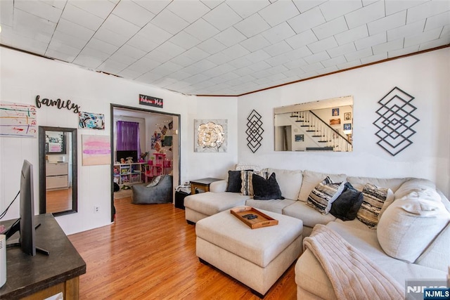 living room featuring hardwood / wood-style flooring and crown molding